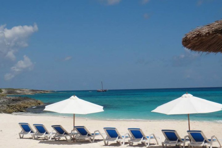 a group of lawn chairs sitting on top of a beach